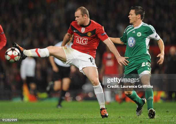 Wayne Rooney of Manchester United holds off the challenge of Sascha Riether of VfL Wolfsburg during the UEFA Champions League Group B match between...