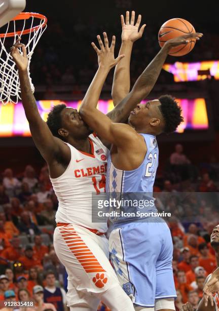 Elijah Thomas forward Clemson University Tigers fouls Sterling Manley forward University of North Carolina as he takes a shot during a college...