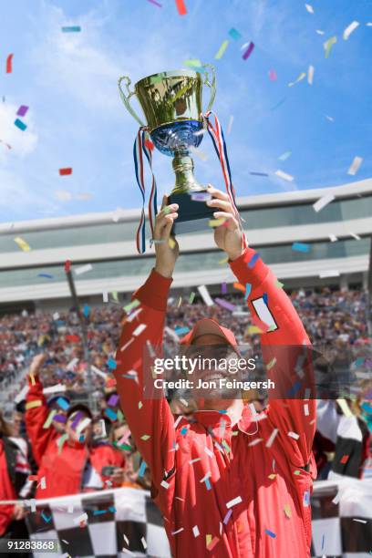 winning race car driver holding trophy. - holding trophy cup stock pictures, royalty-free photos & images