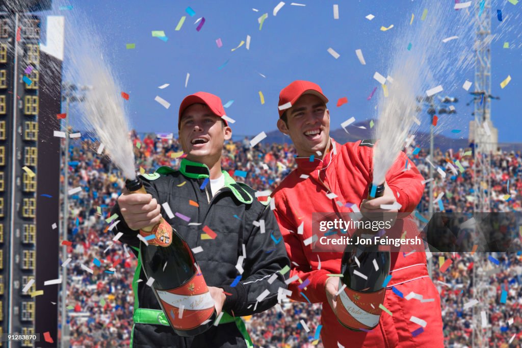 Winning race car drivers spraying champagne.