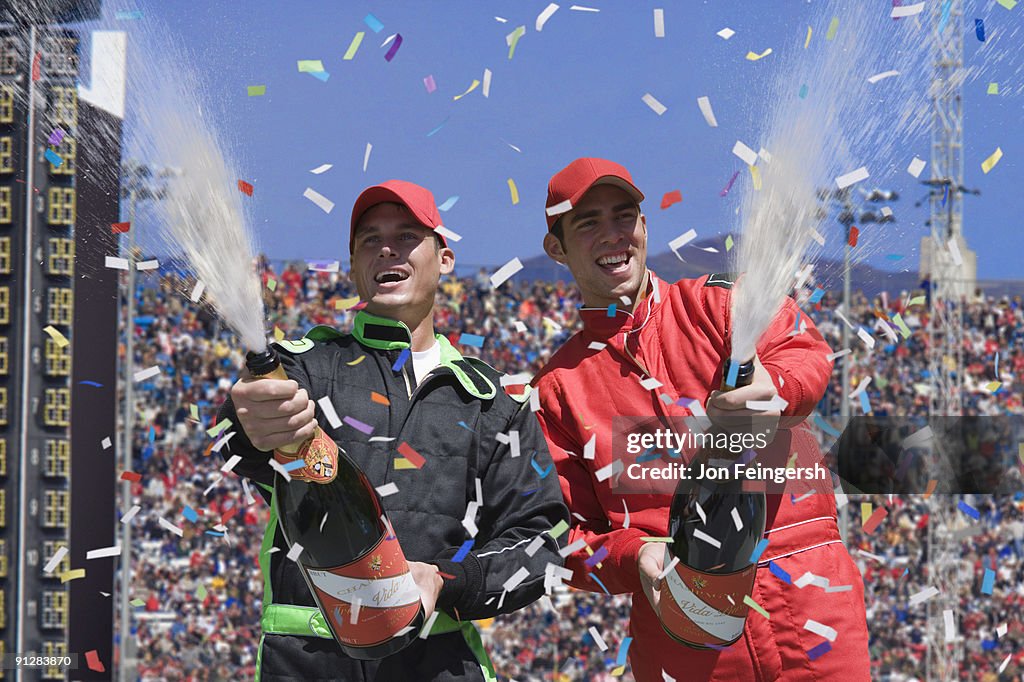Winning race car drivers spraying champagne.