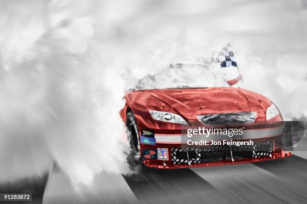 winning nascar driver breaking through smoke. - stock car racing - fotografias e filmes do acervo