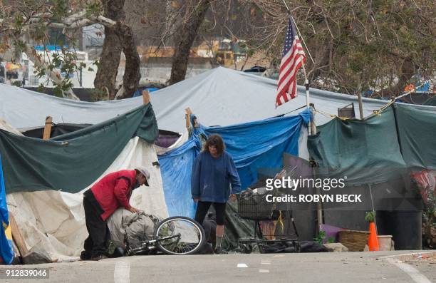 Homeless encampment made of tents and tarps lines the Santa Ana riverbed near Angel Stadium in Anaheim, California, January 25, 2018. - People living...