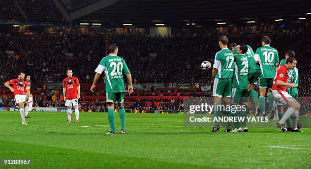 Manchester United's Welsh midfielder Ryan Giggs takes a free kick which hits Manchester United's Irish defender John O'Shea on it's way to score...