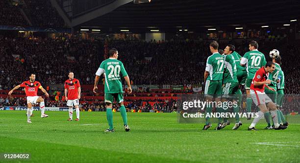 Manchester United's Welsh midfielder Ryan Giggs takes a free kick which hits Manchester United's Irish defender John O'Shea on it's way to score...