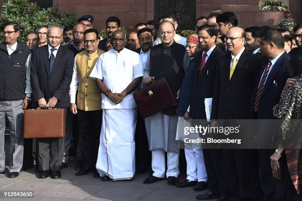 Arun Jaitley, India's finance minister, center right, and other members of the finance ministry stand for a photograph outside the North Block of the...