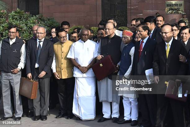 Arun Jaitley, India's finance minister, center right, and other members of the finance ministry stand for a photograph outside the North Block of the...