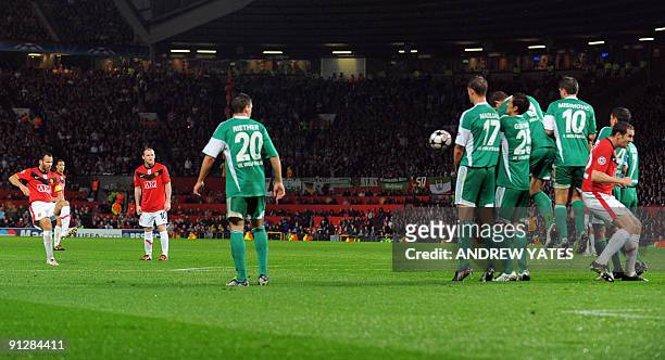 Manchester United's Welsh midfielder Ryan Giggs takes a free kick which hits Manchester United's Irish defender John O'Shea on it's way to score...