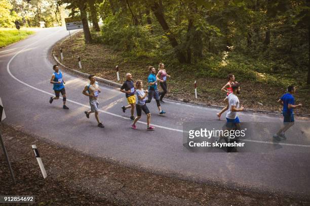 above view of large group of marathon runners having a race on the road. - looking down the road stock pictures, royalty-free photos & images