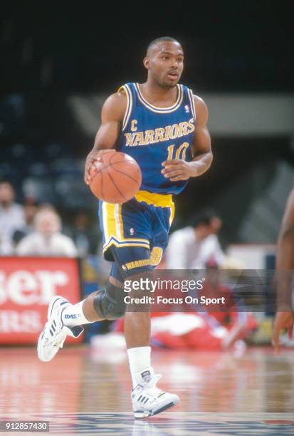 Tim Hardaway of the Golden State Warriors dribbles the ball up court against the Washington Bullets during an NBA basketball game circa 1992 at the...