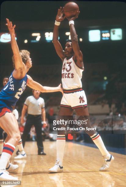 Toby Knight of the New York Knicks looks to pass the ball over the top of Jan Van Breda Kolff of the New Jersey Nets during an NBA basketball game...