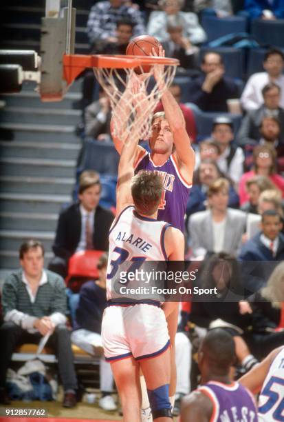 Tom Chambers of the Phoenix Suns shoots over Mark Alarie of the Washington Bullets during an NBA basketball game circa 1990 at the Capital Centre in...