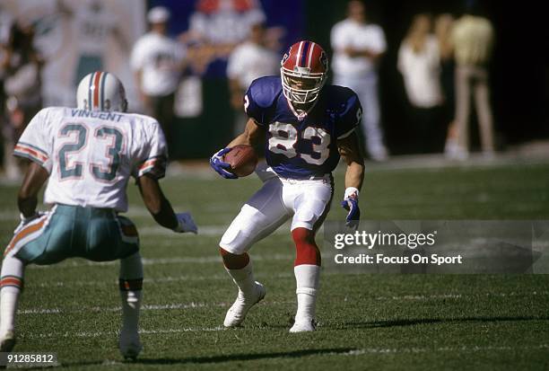 1990s: Wide Receiver Andre Reed of the Buffalo Bills in action looking to get pass Troy Vincent of the Miami Dolphins during an NFL football game...