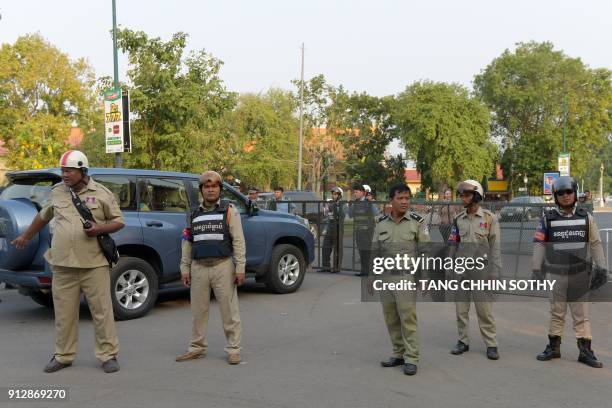 Cambodian police officials stand guard as they block a street near the appeals court in Phnom Penh on February 1, 2018. Cambodia's opposition leader...