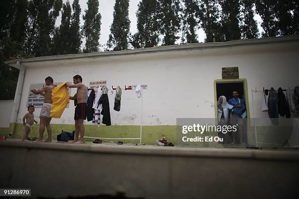 Turkish families dress after bathing in a mineral-rich pool full of 'doctor fish', on September 13, 2009 in Kangal, 105 kilometers south of the...