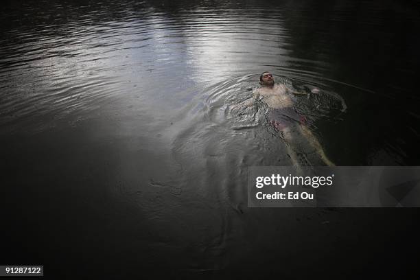 Turkish man bathes in a mineral-rich pool full of 'doctor fish', on September 13, 2009 in Kangal, 105 kilometers south of the central Turkish city of...