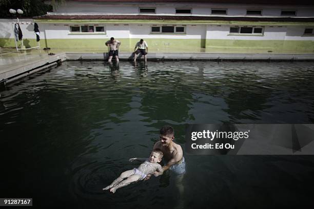 Turkish families bathe in a mineral-rich pool full of 'doctor fish', on September 13, 2009 in Kangal, 105 kilometers south of the central Turkish...