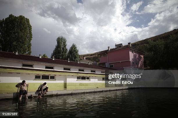 Turkish families bathe in a mineral-rich pool full of 'doctor fish', on September 13, 2009 in Kangal, 105 kilometers south of the central Turkish...