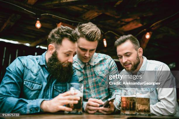 jungs von pub trinken bier und smartphone betrachten - men friends beer outside stock-fotos und bilder