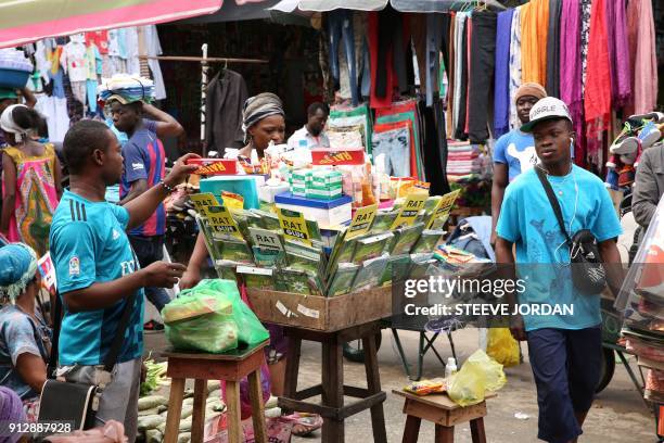 Man looks at the products displayed on a market stall selling rat poison at a steet market, in Libreville, on January 31, 2018. - The consumption of...