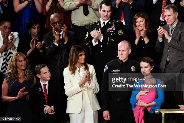 Officer Ryan Holets and his wife, lower right holding baby, at the State of the Union speech before members of Congress in the House chamber of the...