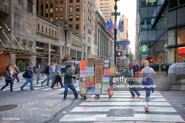 hommes poussant des boîtes sur un chariot à main - diable-chariots-et-charrettes photos et images de collection