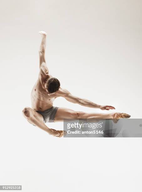 athletic ballet dancer in a perfect shape performing over the grey background - art modeling studio stock pictures, royalty-free photos & images