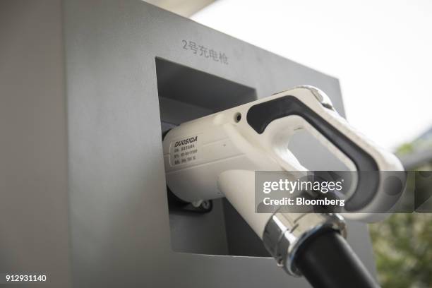 Plug sits at a charging station operated by an electric vehicle dealership in Ningde, Fujian Province, China, on Monday, Jan. 29, 2018. China...