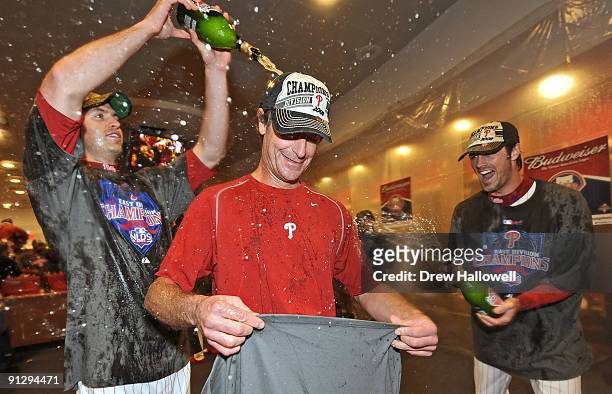 Jamie Moyer of the Philadelphia Phillies gets champagne pured on him by teammates J.A. Happ and Cole Hamels after beating the Houston Astros 10-3 and...