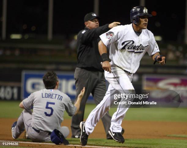 Everth Cabrera of the San Diego Chargers is called to home by the umpire after third-baseman Mark Loretta of the Los Angeles Dodgers impeded his...