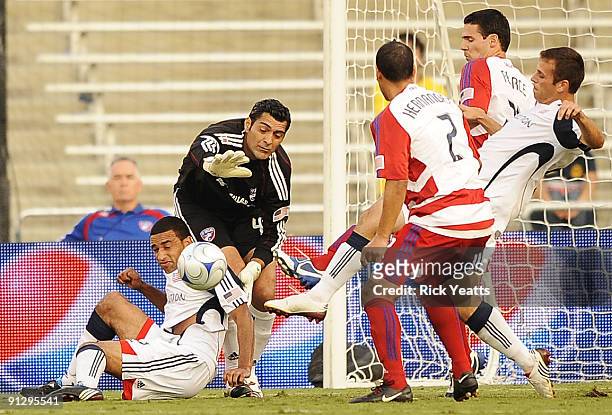 Dario Sala of the FC Dallas tries to make a save with pressure from Amaechi Igwe of the New England Revolution as Chris Tierney of the New England...
