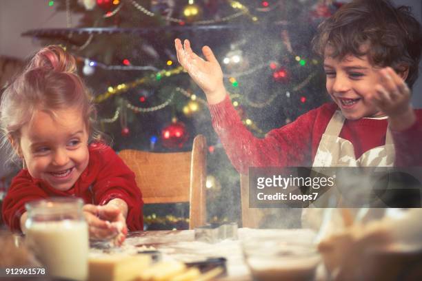 brother and sister baking cookies - kids cooking christmas stock pictures, royalty-free photos & images
