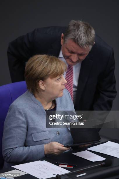 German Chancellor Angela Merkel speaks with Health Minister Hermann Groehe as she attends debates at the Bundestag over a proposal concerning the...