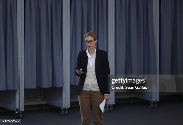 Alice Weidel of the right-wing Alternative for Germany political party holds a mobile phone as she attends debates at the Bundestag over a proposal...