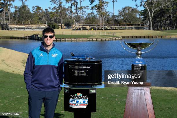 Driver Denny Hamlin poses with the Daytona 500 and FedEx Cup trophies on the 17th hole at THE PLAYERS Stadium Course at TPC Sawgrass on January 31,...