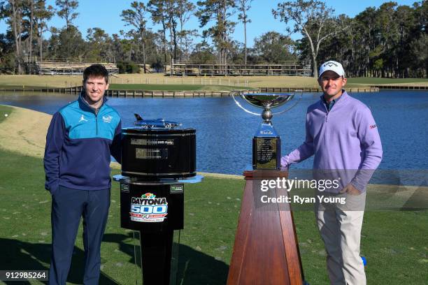 Denny Hamlin and Sam Saunders pose with the Daytona 500 and FedEx Cup trophies on the 17th hole at THE PLAYERS Stadium Course at TPC Sawgrass on...