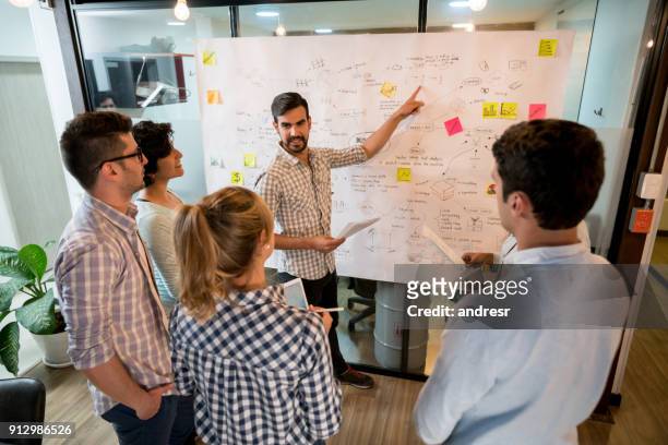man in a business meeting at the office pointing at a business plan - business plan stock pictures, royalty-free photos & images