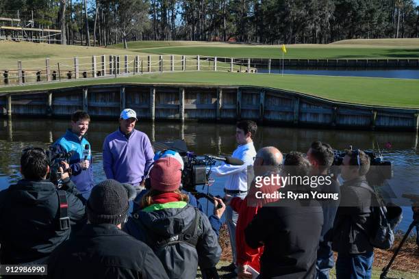 Driver Denny Hamlin and PGA TOUR golfer Sam Saunders answer questions from the media on the 17th hole at THE PLAYERS Stadium Course at TPC Sawgrass...