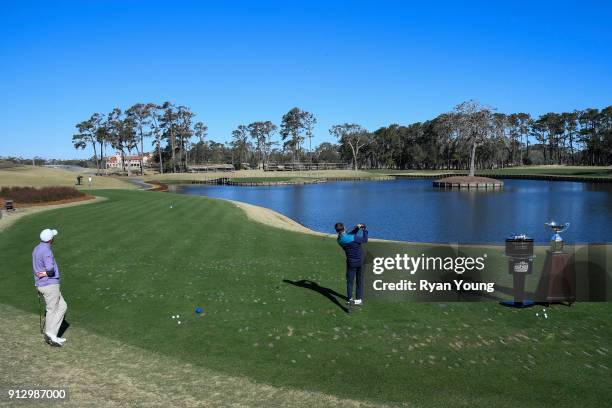 Driver Denny Hamlin and PGA TOUR golfer Sam Saunders on the 17th hole at THE PLAYERS Stadium Course at TPC Sawgrass on January 31, 2018 in Ponte...