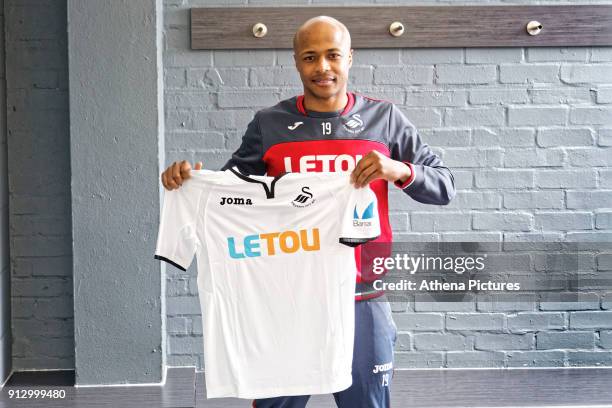 Andre Ayew holds a team shirt as he is unveiled as a new Swansea City signing at The Fairwood Training Ground on February 01, 2018 in Swansea, Wales.