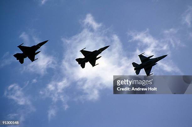 three fighter jets in silhouette against sky - military plane stock pictures, royalty-free photos & images