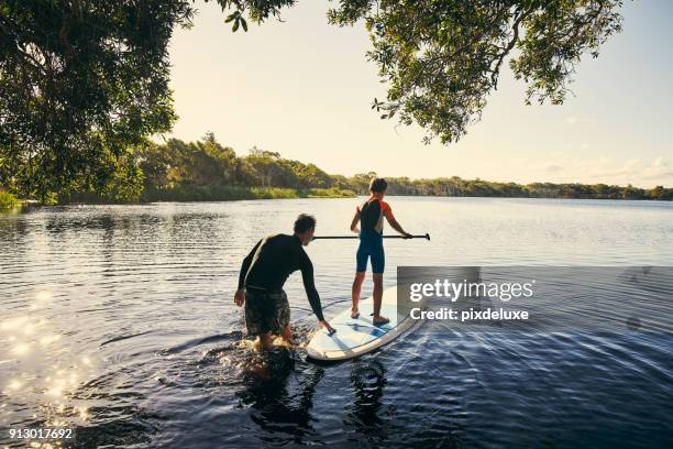 mijn jongen onderwijzen hoe te peddelen - activities in the sun stockfoto's en -beelden