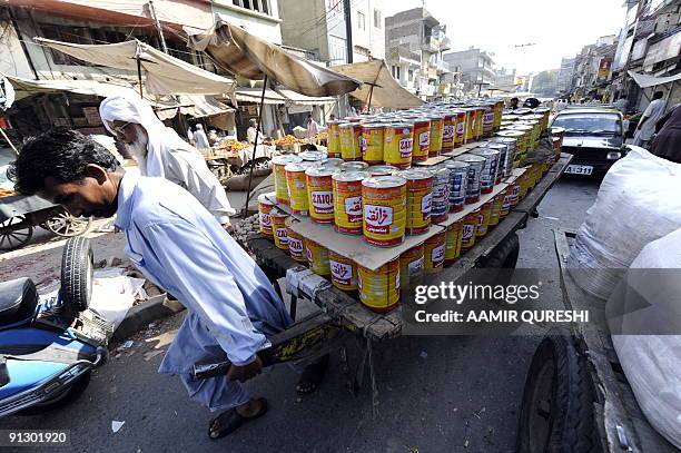 Pakistani labourer pulls a cart laden with cooking oil through a main wholesale market in Rawalpindi on September 30, 2009. Pakistan's central bank...