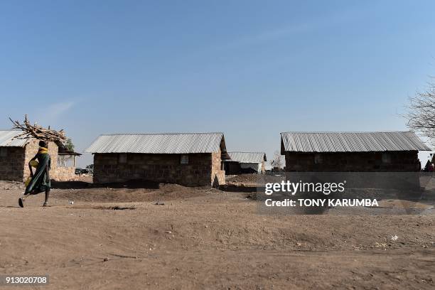 Woman from the local Turkana community carries firewood on her head into the Kalobeyei refugee settlement scheme in Kakuma, a collaborative effort by...