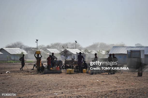 Men and women from the local Turkana community fetch water their animals at a bore hole at the Kalobeyei refugee settlement scheme in Kakuma, a...
