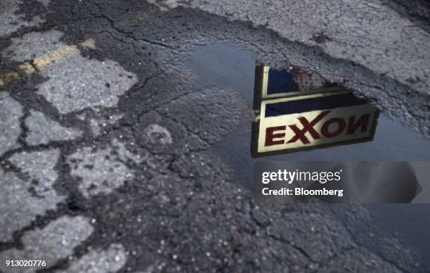 Exxon Mobil Corp. Signage is reflected in a puddle at a gas station in Nashport, Ohio, U.S., on Friday, Jan. 26, 2018. Exxon Mobil Corp. Is scheduled...