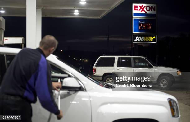 An attendant cleans the windows of a vehicle for a customer at an Exxon Mobil Corp. Gas station in Nashport, Ohio, U.S., on Friday, Jan. 26, 2018....