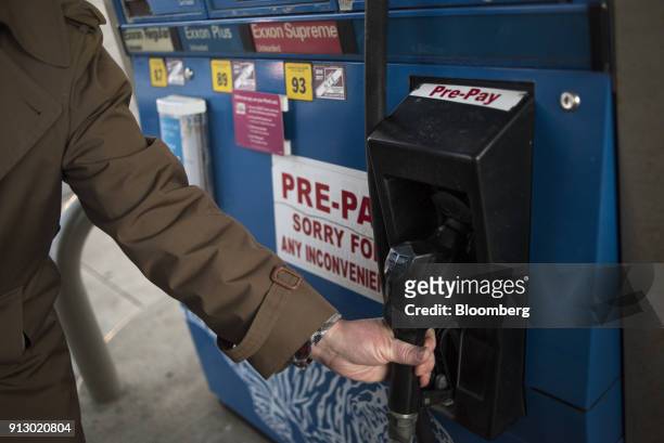 Customer finishes pumping fuel at an Exxon Mobil Corp. Gas station in Nashport, Ohio, U.S., on Friday, Jan. 26, 2018. Exxon Mobil Corp. Is scheduled...