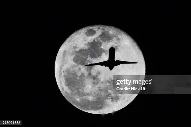 Passenger airliner makes its path across the the moon before becoming a so-called 'super blue blood moon' January 31, 2018 seen from Whittier,...