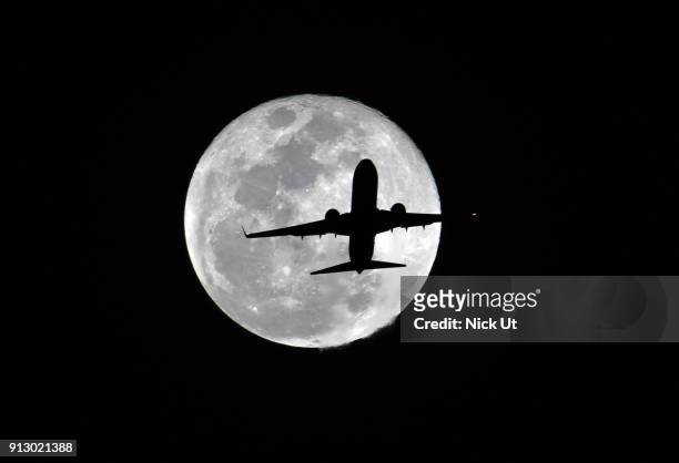 Passenger airliner makes its path across the the moon before becoming a so-called 'super blue blood moon' January 31, 2018 seen from Whittier,...